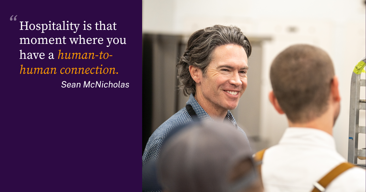 Sean McNicholas of SSA Group is smiling at a man in a kitchen where they are working to improve the guest experience.